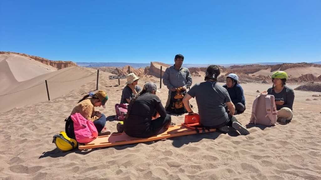 Alumnos realizando práctica de primeros auxilios en curso WFR en el desierto Valle de la Luna en Chile
